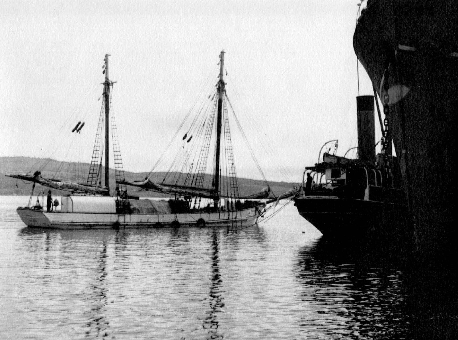 Ketch berthed alongside a ship for off-loading.