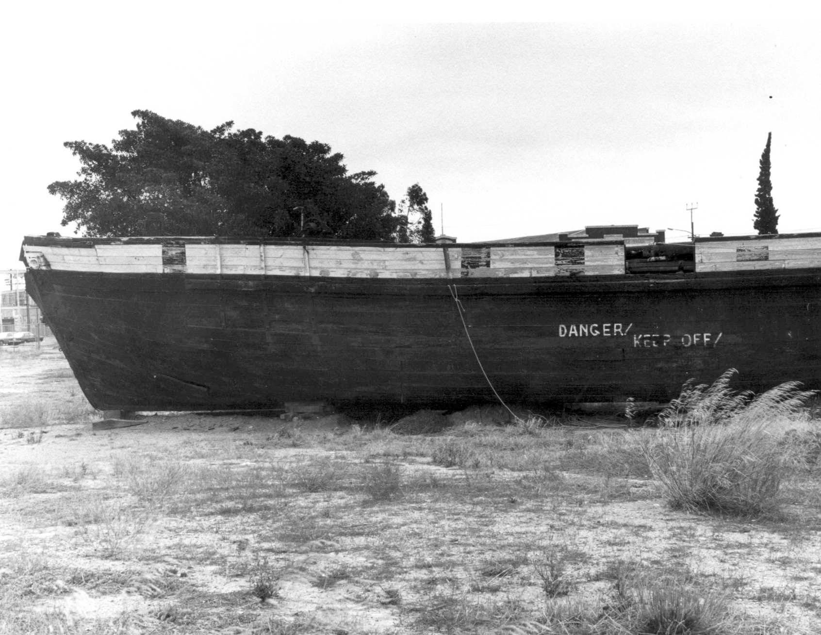 This image shows the hull of vessel on land, reading DANGER, KEEP OFF.