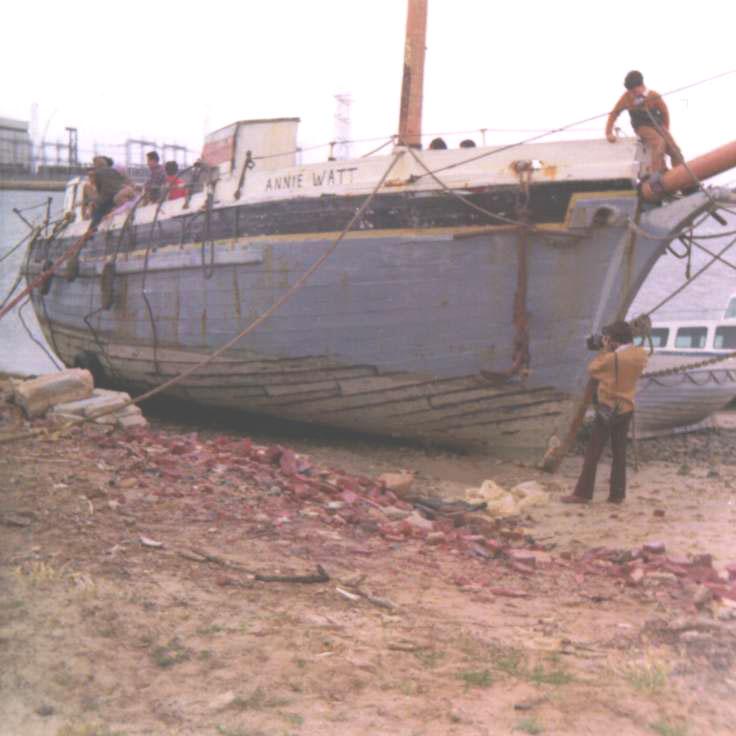 This image shows the hull of vessel, on land, in a state of disrepair.