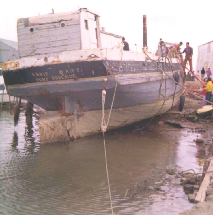 This image shows the stern of vessel, on land, in a state of disrepair.