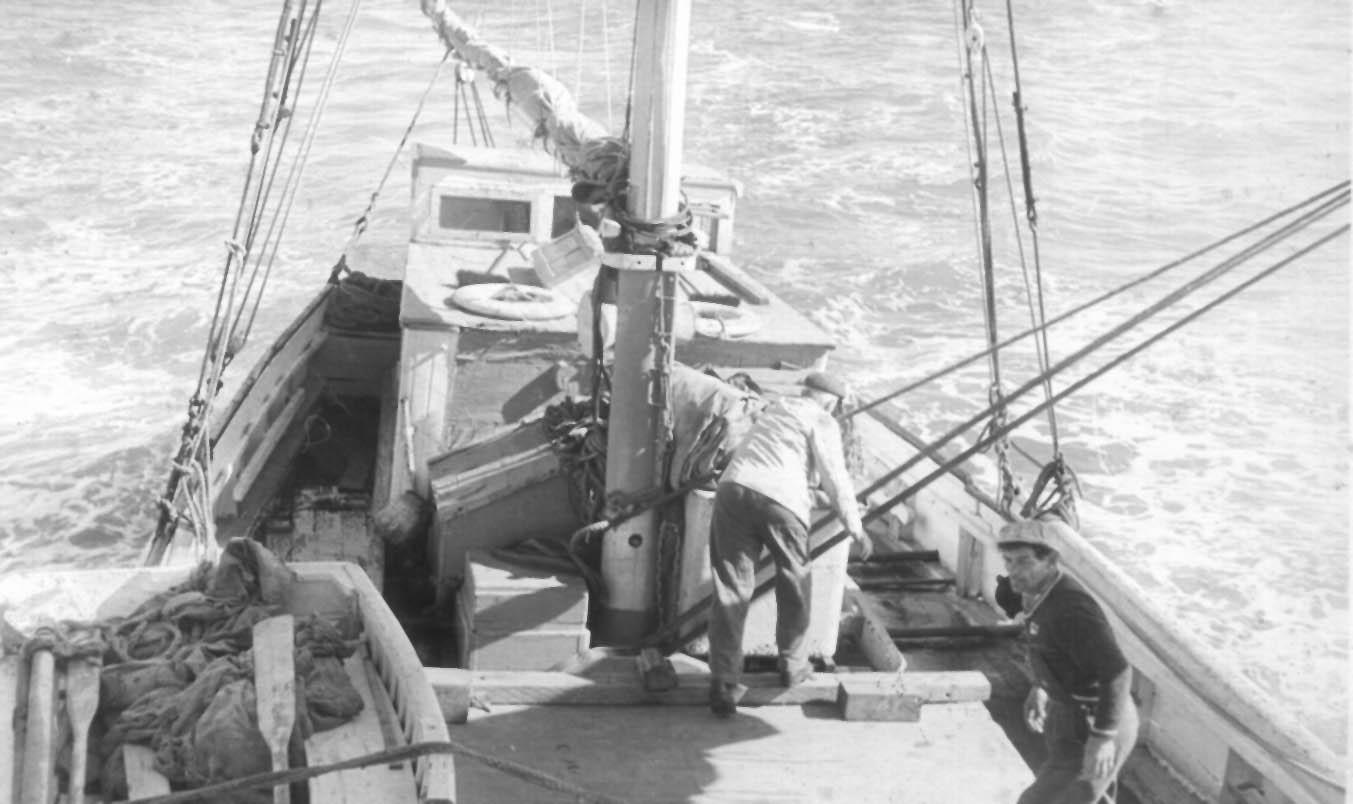 Ketch, crew on deck at sea.