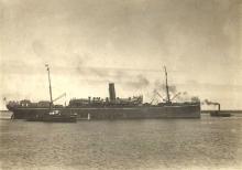 Image: large steamship with tug boats in water