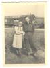 Image: man and woman standing together in front of railway freight carriages in field