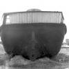 This image shows the stern of vessel, on land, in a state of disrepair.
