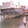 This image shows the stern of vessel, on land, in a state of disrepair.